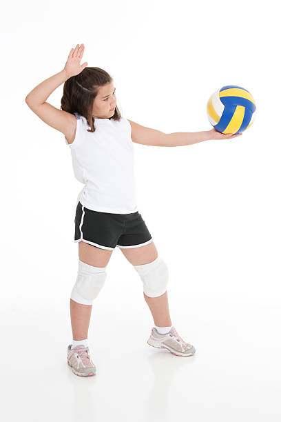 Caucasian Kids Cute Caucasian girl serving the ball in volleyball young volleyball girl stock pictures, royalty-free photos & images