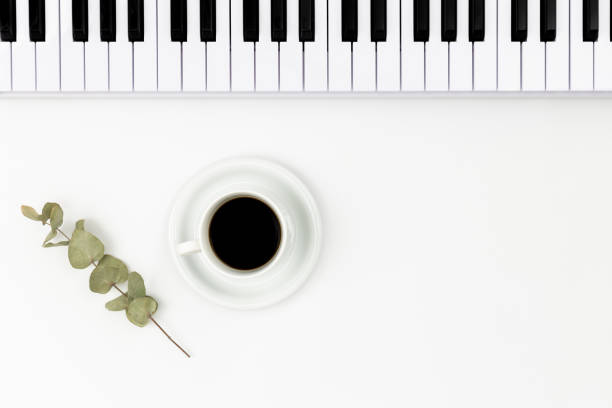 istock Musical keyboard and a cup of coffee on a white background, top view. 1492108696