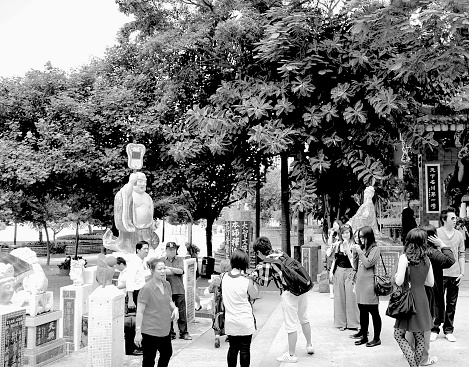 Tin Hau Temple in Repulse Bay is a very colorful and ornate Buddhist temple, but it is also an immensely popular tourist attraction in Hong Kong. This black and white photograph shows a small segment of the temple, along with a crowd of tourists. The image was captured during September of 2010.