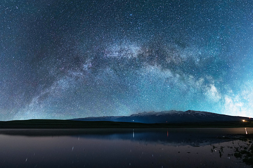Beautiful night landscape. Bright Milky Way galaxy over the lake .