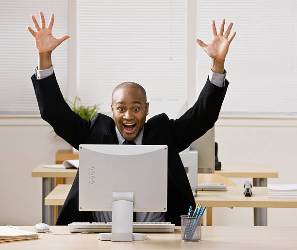 istock Businessman sitting at desk cheering and celebrating 149212070