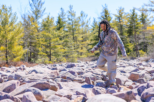 Boulder Field - Ice Age geological formation. Man with locks on touristic vacation in mountain area of Hickory Run Boulder Field, State Park in Poconos region, Pennsylvania