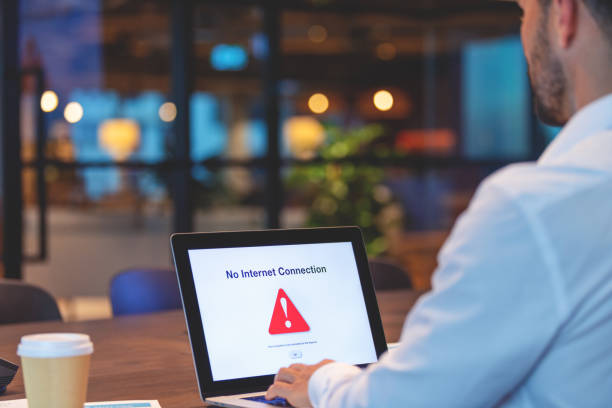 Businessman looking at an internet failure screen on a computer. Businessman looking at an internet failure screen on a computer. He is in an office offline stock pictures, royalty-free photos & images