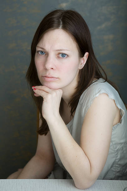 serious woman with blue eyes sitting stock photo