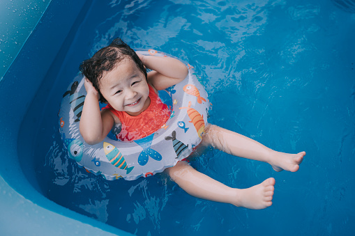 asian chinese baby girl enjoying me time in inflatable swimming pool