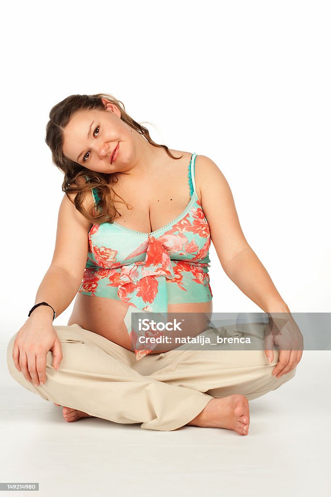 Pregnant yoga Beautiful smiling pregnant woman doing a yoga in the lotus position. Abdomen Stock Photo