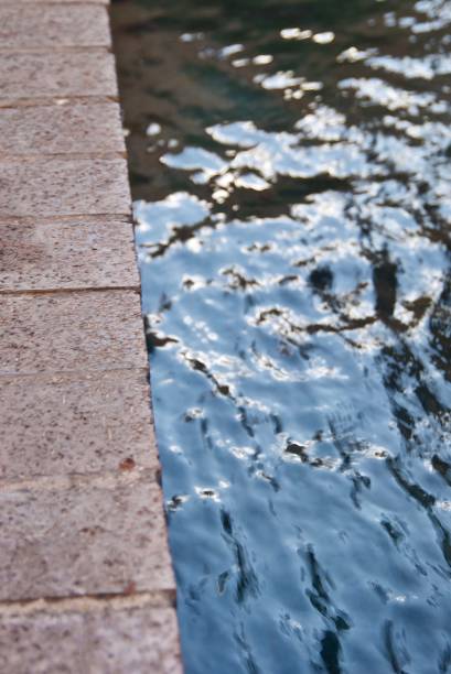 istock Reflection of Rippled Water Along A Brick Border Fountain 1492150133