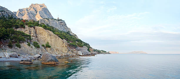 istock Evening rocky coastline panorama and old lighthouse on slope 149215300