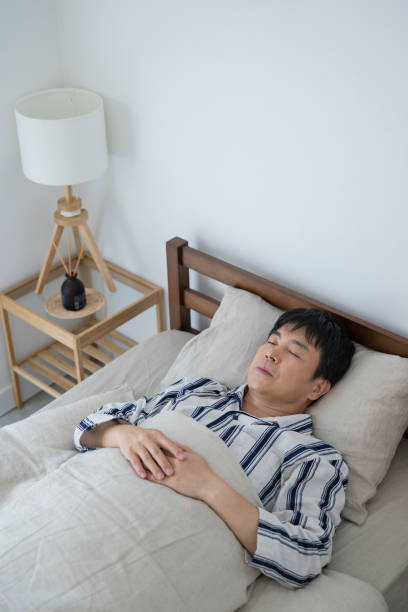 istock Middle-aged man asleep in bed, morning 1492154854