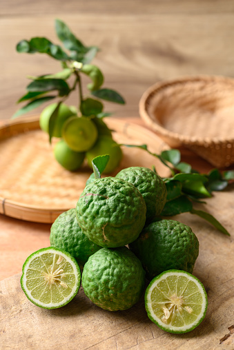 Kaffir lime and lime fruit on wooden background, Organic ingredients in Thai cuisne, beauty and cosmetics