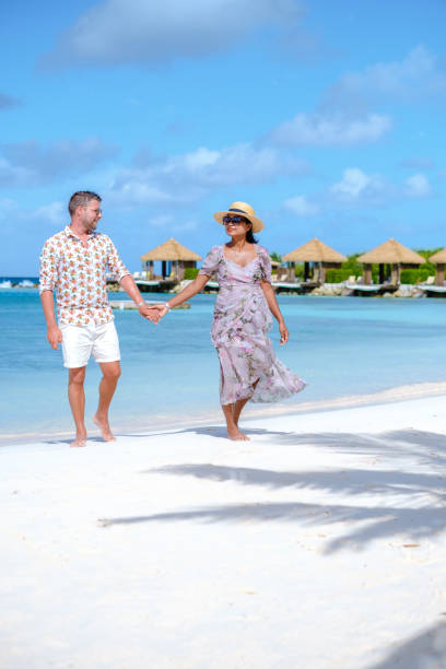 para mężczyzn i kobiet na wakacjach na aruba island caribbean spaceruje po tropikalnej białej plaży - aruba honeymoon tourist resort vacations zdjęcia i obrazy z banku zdjęć
