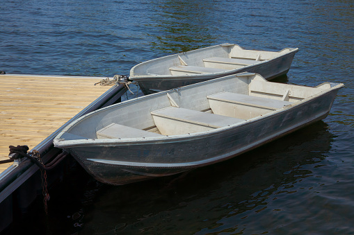 two boats on a lake rowboats docked on a calm water nautical peaceful tranquil scene in magog quebec