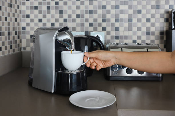 istock Espresso shot dripping to cup through coffee maker in kitchen. 1492167405
