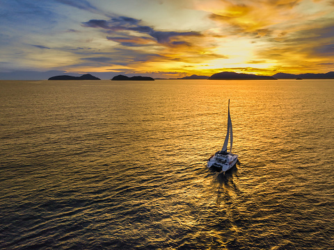 Aerial view of a catamaran on the andaman sea. Sunset sailing in Phuket, Thailand.