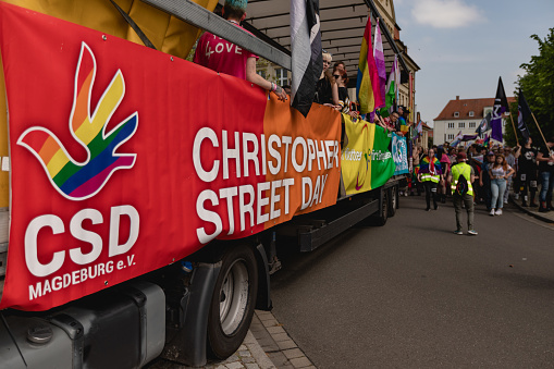 Dessau, Saxony-Anhalt, Germany, Europe - 20 May 2023: LGBTQ+ celebration in Dessau, Germany. CSD - Christopher Street Day. Gay pride event 2023, people with gender symbols walking in the town. Cover on the big truck.
