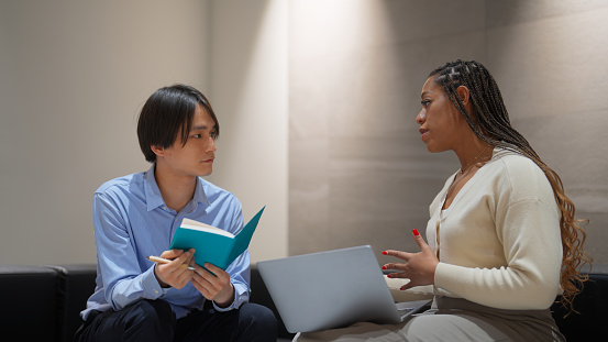 Two multi-ethnic business people are having business discussion and consultation in the office.