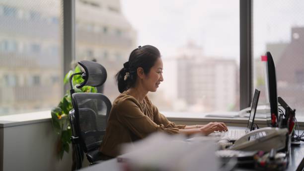 geschäftsfrau nimmt an online-videokonferenz auf computer im büro teil - japanese ethnicity train women asian ethnicity stock-fotos und bilder