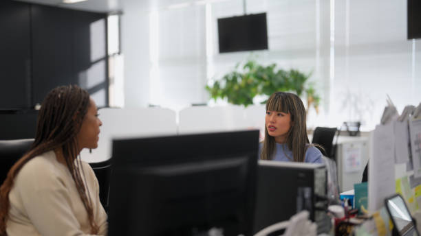 istock Two multi-ethnic businesswoman talking casually with each other in modern office 1492179097