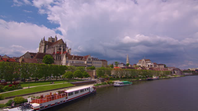 Establishing shot time lapse. Beautiful street with old traditional French houses in the center of Auxerre with clouds in the background. Legacy of French history. Colorful houses in France