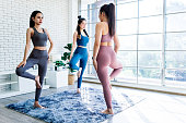 Group of young women practicing yoga in a fitness class