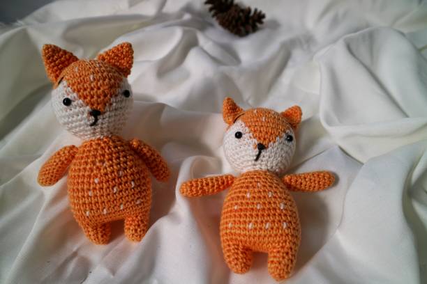 istock Orange wolf crochet handmade doll made from yarn. Stuffed toy on fluffy background. 1492185371