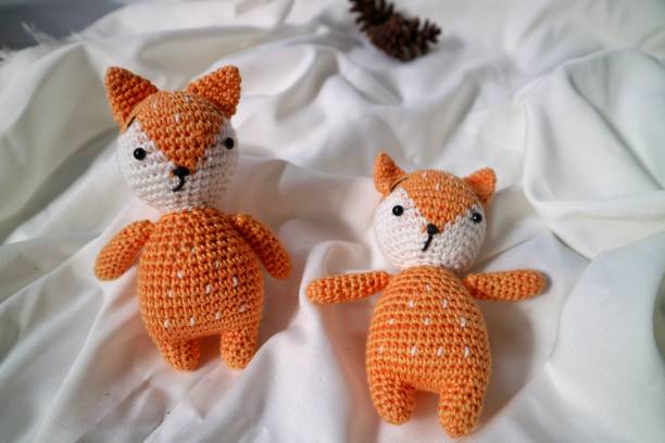 istock Orange wolf crochet handmade doll made from yarn. Stuffed toy on fluffy background. 1492185403