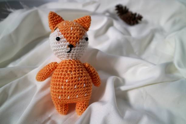 istock Orange wolf crochet handmade doll made from yarn. Stuffed toy on fluffy background. 1492185423
