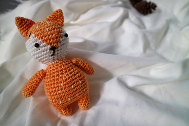 istock Orange wolf crochet handmade doll made from yarn. Stuffed toy on fluffy background. 1492185449