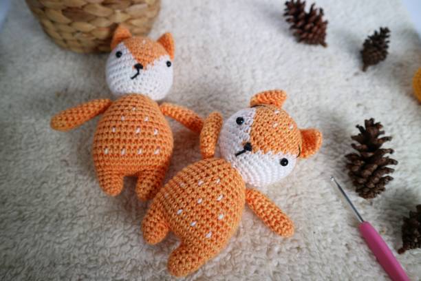 istock Orange wolf crochet handmade doll made from yarn. Stuffed toy on fluffy background. 1492187668