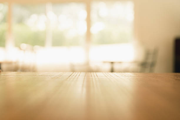 Empty old wood table in front of living room with sofa, lamp, chair and window decorated in comfortable tones, suitable for relaxation. Can be used for display or montage for show your products.