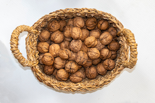 Walnuts in a basket on a white background