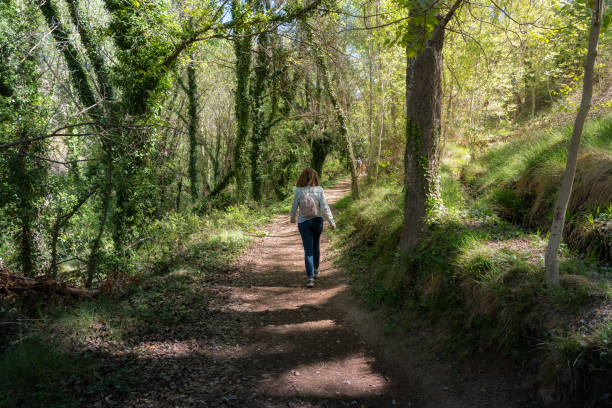 istock Woman walking backwards along a path among forest vegetation in Anento, Zaragoza. 1492190232