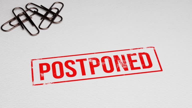 Postponed grunge rubber stamp putting on white paper with paper pins in the background. 4k 3D animation