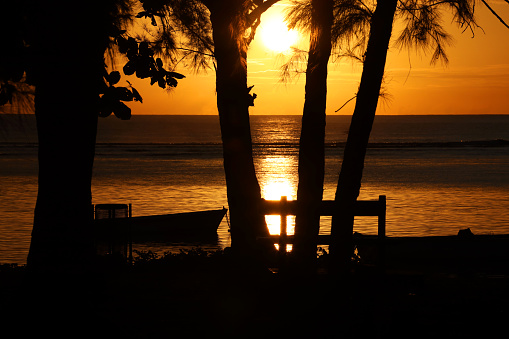 Golden, tropical sunset behind island