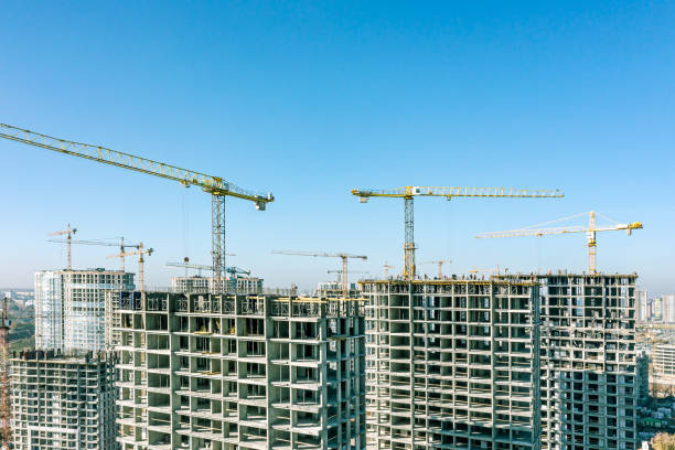 istock yellow cranes on construction site near multistory residential houses under construction. aerial view on blue sky background. 1492198633