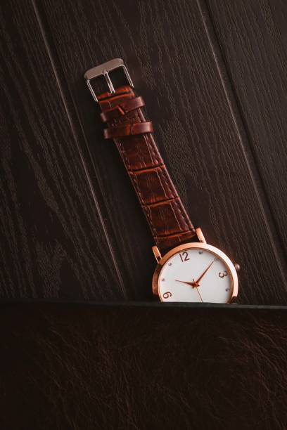 istock Watch with brown leather strap on the wooden table 1492201251