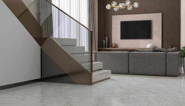 istock Luxury, modern L shape granite stone staircase, tempered glass panel, gold steel handrail in wood panel wall living room, sofa in sunlight from window curtain on marble floor for 1492201810