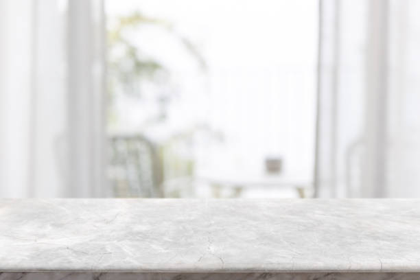 istock Empty white marble stone table top and blurred living room at home interior with window curtain background. - can used for display or montage your products. 1492206436