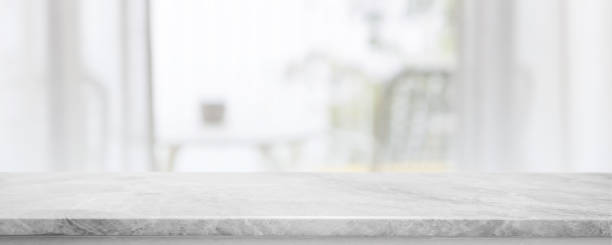 istock Empty white marble stone table top and blurred living room at home interior with window curtain background. - can used for display or montage your products. 1492206437
