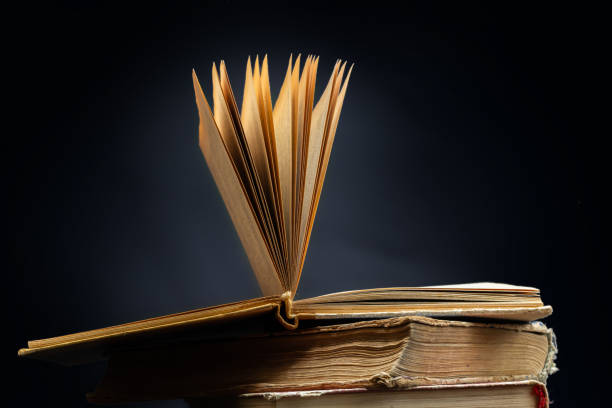 istock Stack of hardcover old books with an open book on a dark background. Bookshelf shop, Knowledge publications, literature. Bookish bookstore bookstore 1492208639
