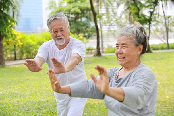 un couple de personnes âgées asiatiques pratique des exercices de yoga, de tai chi tranining, d’étirement et de méditation ainsi que la relaxation pour une santé dans le parc en plein air après la retraite. concept de style de vie en plein air pour - tai chi photos et images de collection