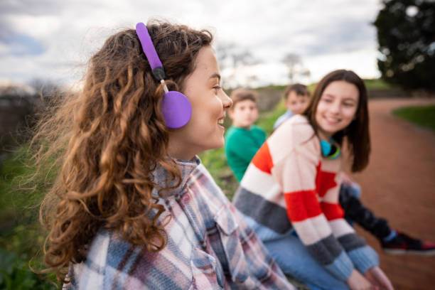 Group of teenagers talking while sitting in park