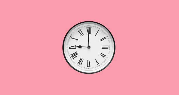 relógio de parede redondo clássico com algarismos romanos isolados no fundo rosa - clock wall clock face clock hand - fotografias e filmes do acervo