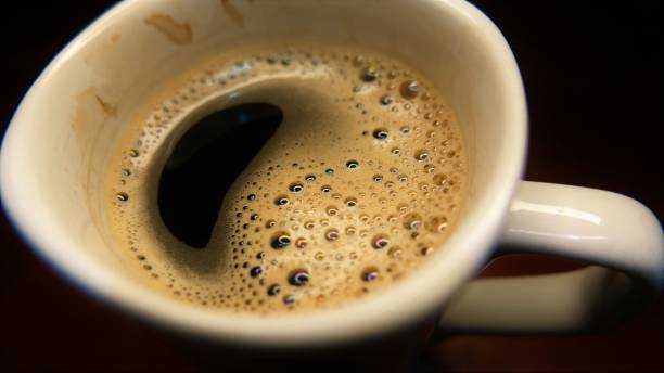 uma caneca de café quente. uma xícara de café, ângulo de close-up. bebidas quentes. xícara de café isolada. uma xícara de café sobre a mesa. copo branco. bolhas em uma xícara de café. xícara de café solúvel. tomar café. café quente - snack coffee instant coffee cappuccino - fotografias e filmes do acervo