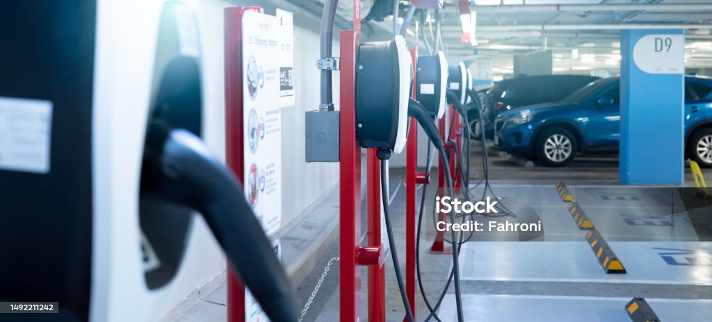Electric car charging station for charge EV battery. Plug for electric vehicle. EV charger. Charging point at car parking lot of the mall. Clean and sustainable energy. Commercial EV charging point. Electric Vehicle Stock Photo
