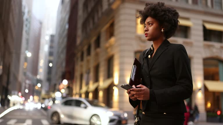 Efficient and Focused: Busy Black Professional Awaits Taxi, Managing Documents and Email