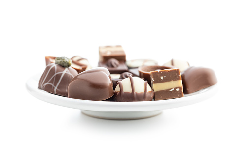 Sweet chocolate pralines.  Tasty chocolate truffles on plate isolated on the white background.