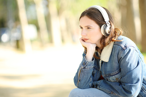 Woman listening audio with hearphone in a park