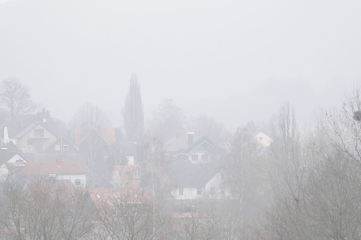 View on a village with houses in a foggy weather in Germany.