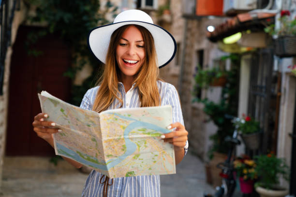 istock Young female tourist with map looking for a way on summer vacation 1492232638